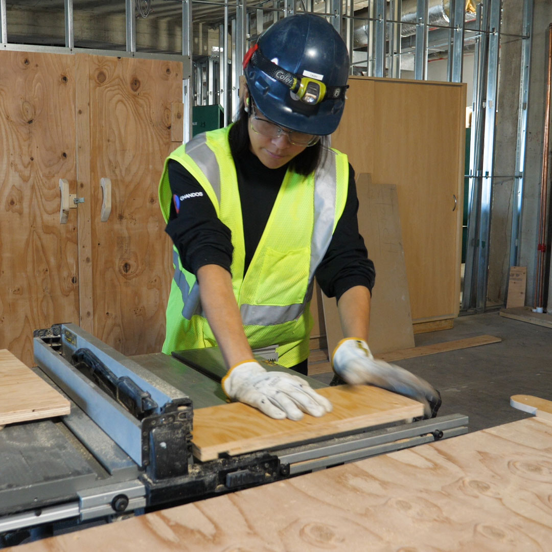 A worker operating a tablesaw
