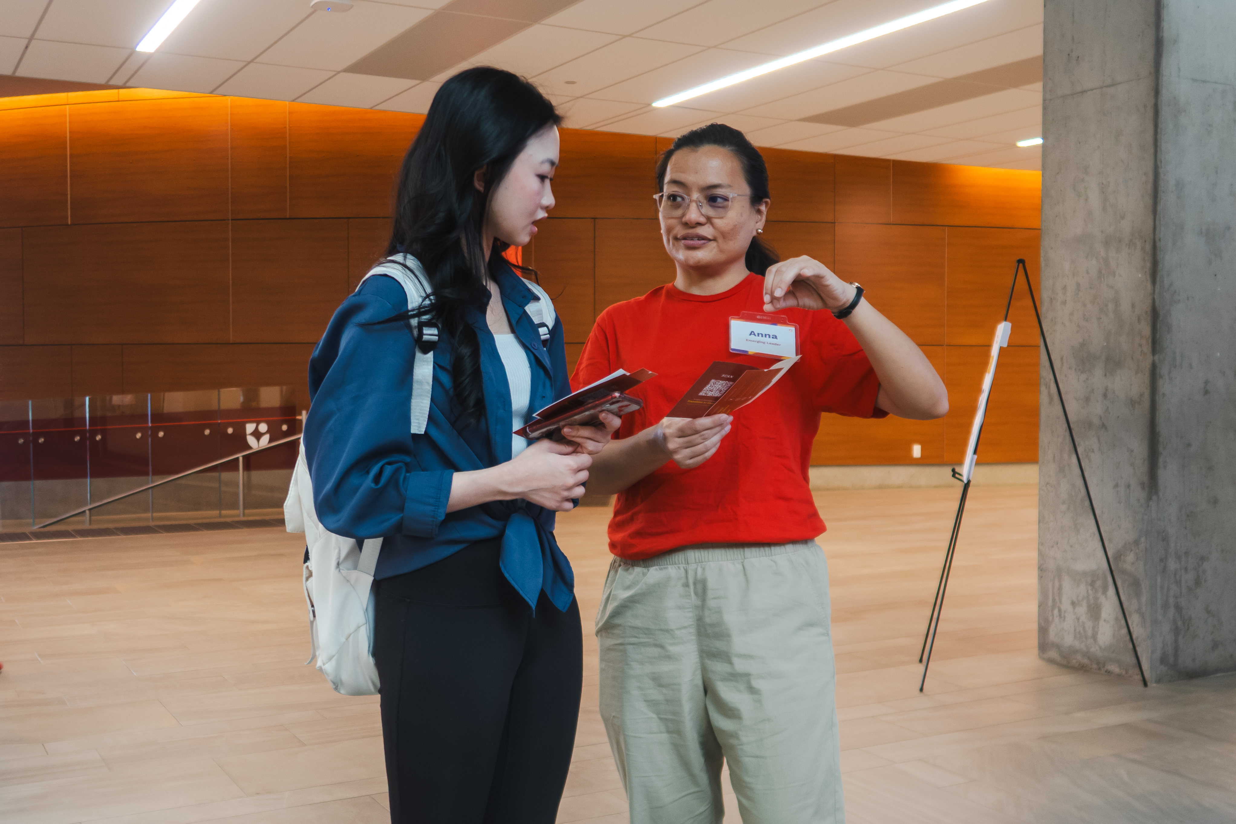 A student helping another student outside of the Atrium